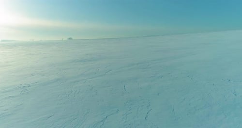 Luftaufnahme der kalten Winterlandschaft, arktische Feldbäume, bedeckt mit Frost, Schnee, Eis, Fluss und Sonne