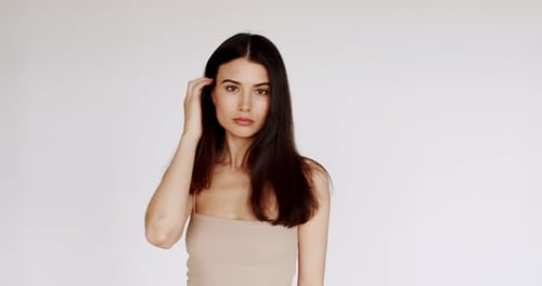 Young Woman Posing in Beige Top and Jeans