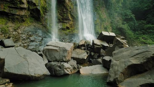 Powerful Nauyaca waterfall crashing into rocky natural pool in Costa Rica