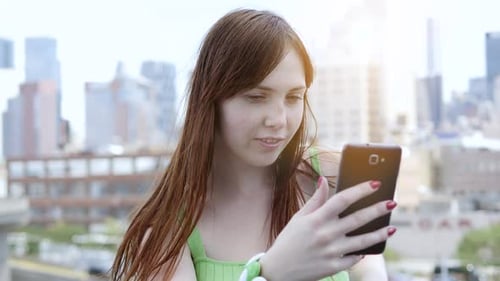 Woman Using Phone on Urban Rooftop