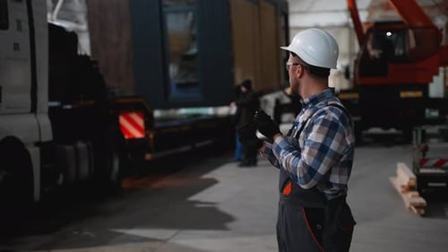 Worker with Walkietalkie Directing Modular Home Loading