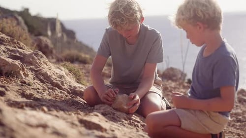 Boys Exploring Rocks On Rough Ground