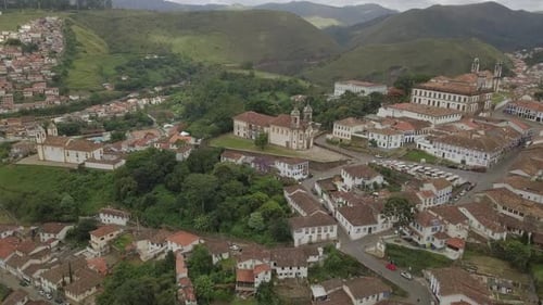 A picturesque vista of Ouro Preto, a colonial town, framed by lush green mountains, designated as a