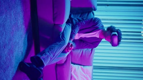 Young Adult Enjoys Virtual Reality on Couch