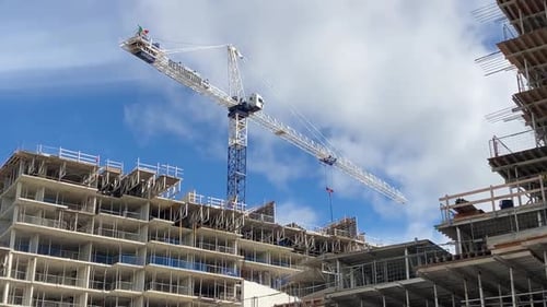 строительный кран и современный жилой комплекс в процессе возведения