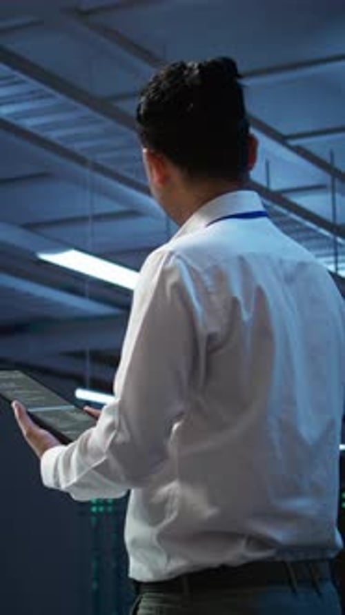 Engineer uses Tablet in Dark Server Room