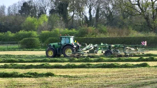 Vue aérienne d'un râteau à foin ramassant de l'herbe pour l'ensilage dans une ferme