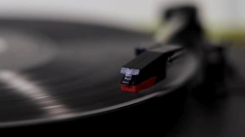 A needle being dropped onto a spinning record/vinyl.