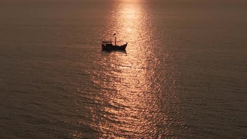 Luftaufnahme eines einsamen Fischerbootes, das durch ein Meer aus Sonnenreflexion navigiert, erzeugt