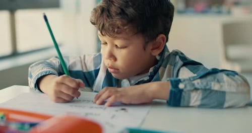School, classroom and boy kid writing, drawing and learning art, color or lesson for skills