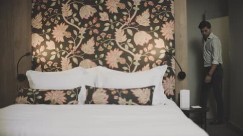 Handsome Man Entering Room at Luxury Hotel. Tired Guy Jumping Bed In