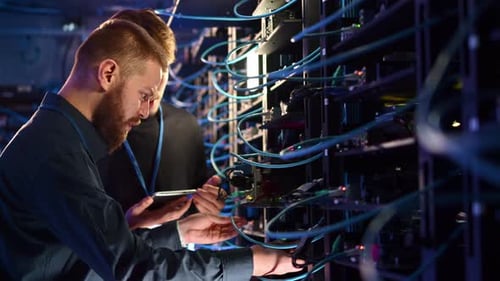 Two men analysing servers in a data centre