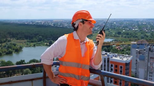 Construction Worker Communicating on the Top of Building