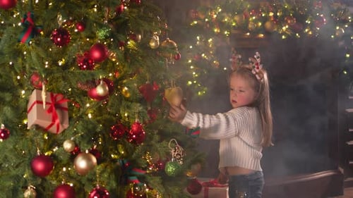 Merry Christmas Xmas Holiday Little Girl Decorating Christmas Tree on Christmas Eve at Home Young