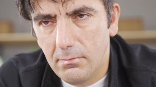 Man looking angry at camera. Big eyes.
