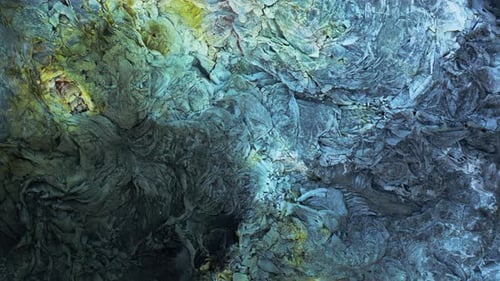 Highly colored surface minerals on solid cracked lava field, top down