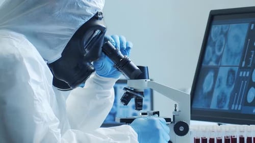 Scientist in Hazmat Suit Using Microscope in Lab