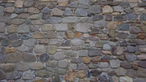 Ancient stone wall of Medieval fortrees located in old town Sozopol. Tilt up of antique wall.