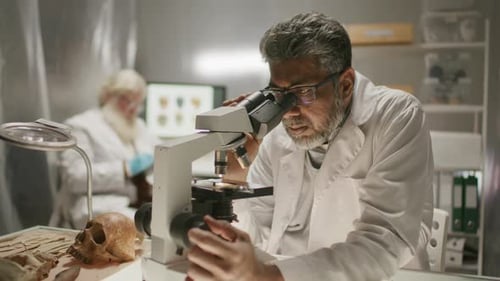 Scientist Conducting Archaeological Research with Microscope in Laboratory