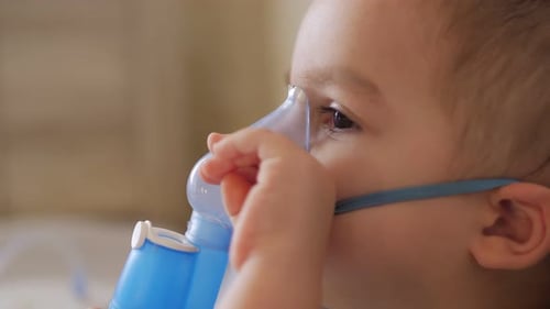 Child Using Nebulizer Mask for Breathing Treatment