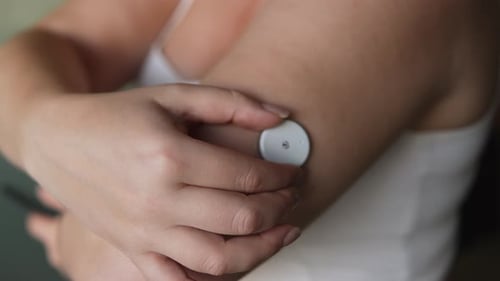 Woman Touches Sensor Attached to Upper Arm