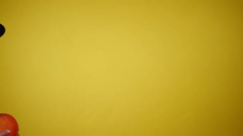 Girl in Witch Costume Holding Pumpkin on Yellow