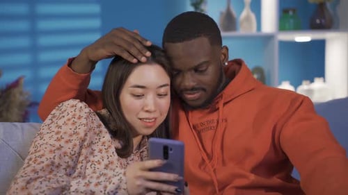 Affectionate Couple Relaxing and Using Phone Together