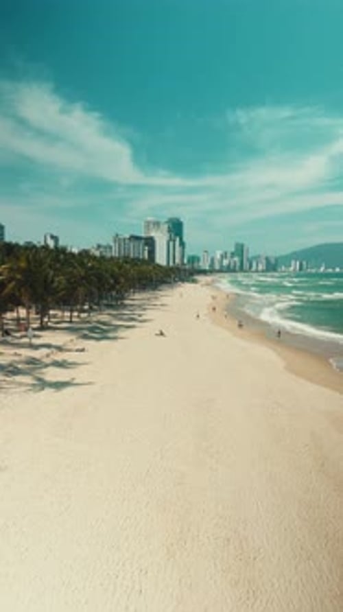 Da nang city skyline rising above a tropical beach with a long stretch of golden