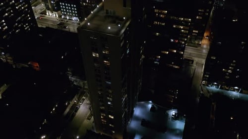 Beautiful aerial drone rotating shot over a high-rise office building in Chicago, USA at night.