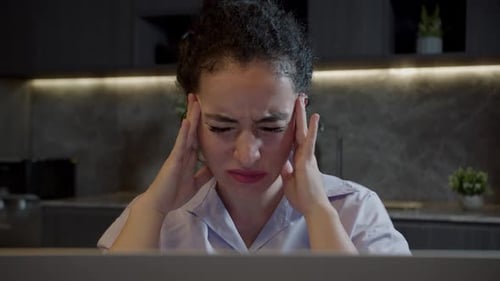 Portrait Une jeune femme épuisée ressent une douleur intense dans sa tête en tenant sa tête