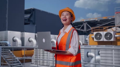 Side View Of Asian Female Engineer Working On A Laptop On Rooftop HVAC