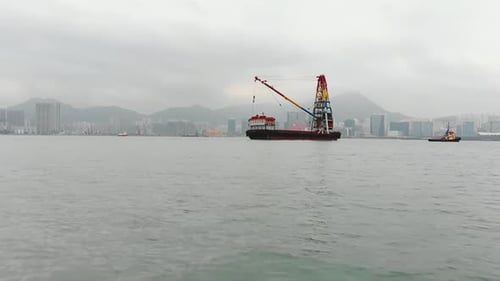 Industrielle Hafenszene mit einer nebligen Skyline und einer bergigen Insel.