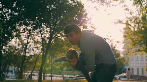 Father with Son Play in the Park in Spring Fly Like Airplanes Happy Family Slow Motion