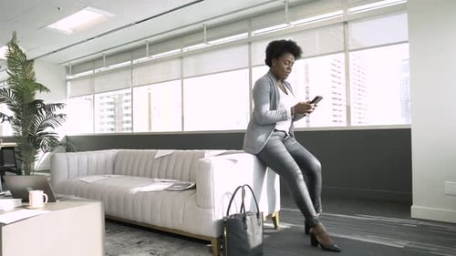 Businesswoman Using Smart Phone in Highrise Office Lobby Adult