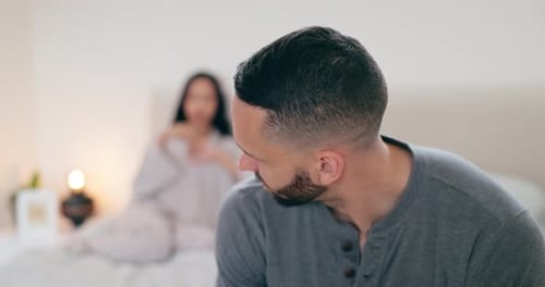 Upset Man Sitting on Bed with Woman