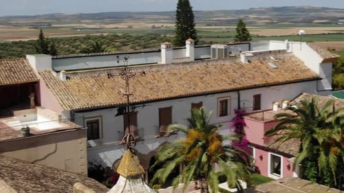 Drone flying around weather vane on top of building in Hacienda El Rosalejo at Villamartin in Andalu