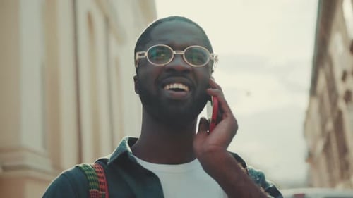 Smiling Young African American with Glasses Man Speak on Phone Stand in City Happy Technology