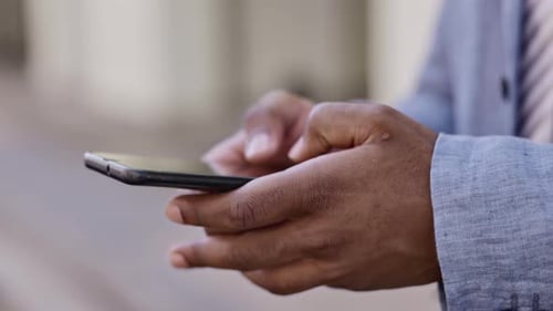 Black man, hands and phone typing in the city for chatting, texting or communication in the street
