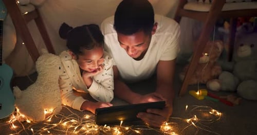 Child and Adult Enjoying Tablet in Cozy Blanket Fort