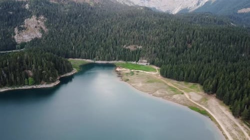Amazing aerial drone view of Crno Jezero or Black lake, pine forest and cliffs in Durmitor national