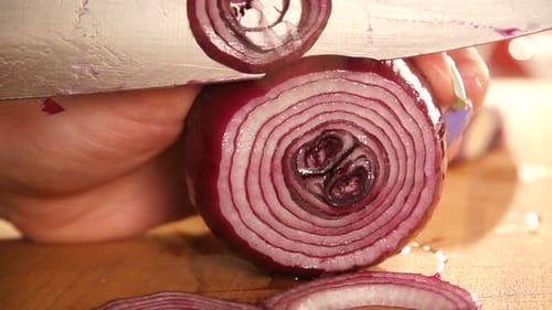 Red onion rings being cut on cutting board