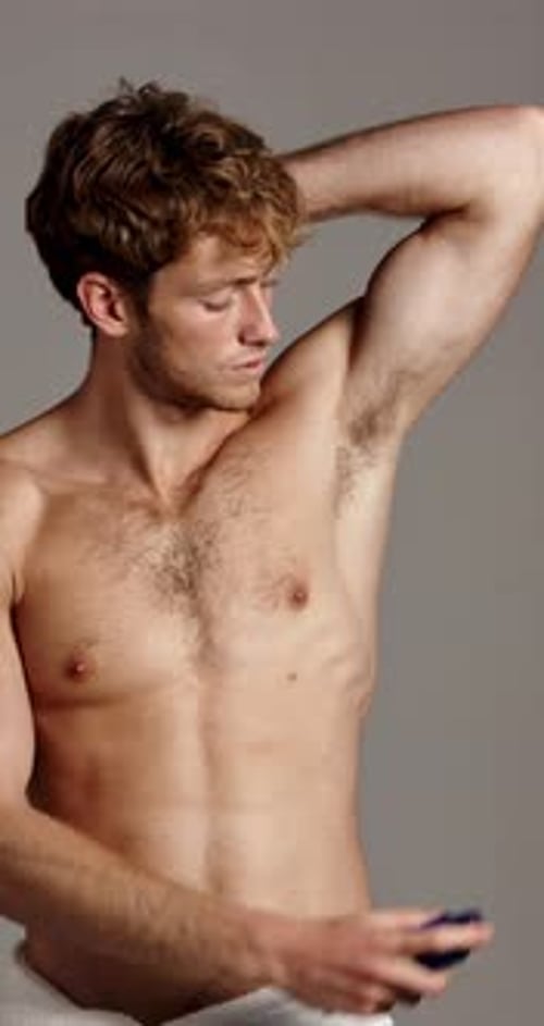 Shirtless Man Sprays Deodorant in Studio