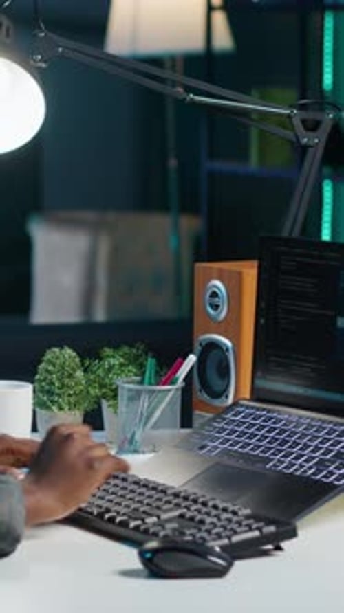 Experte für vertikale Video-KI schreibt Code auf Laptop im Büro einer Wohnung