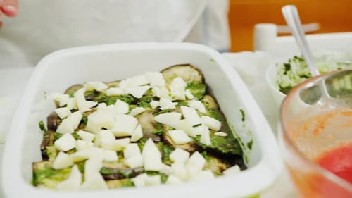 A Womans Hands Preparing an Eggplant and Provola Lasagna