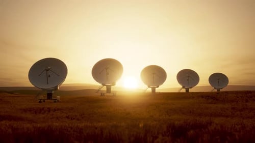 Large Satellite Dishes in a Field at Sunset for Communication