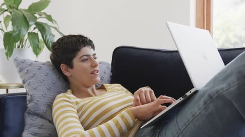 Woman Relaxing on Couch, Using Laptop