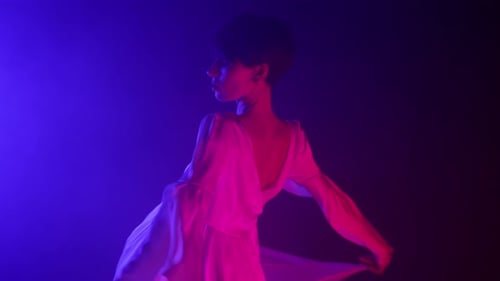 Feminine Frau im Seidenkleid tanzt moderne Choreographie Zeitgenössischer Tanz im Neonstudio