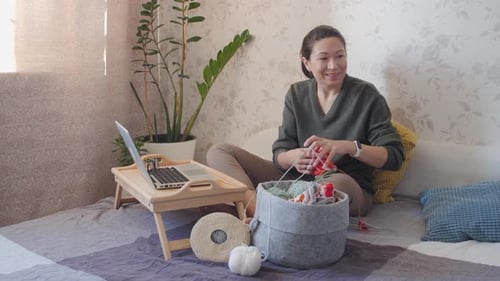 Woman Knitting with Yarn in a Cozy Home Setting