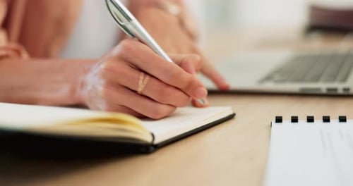 Woman Writing in Notebook on Desk Close Up