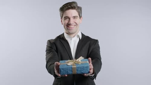 Man Presents Gift with Joyful Expression